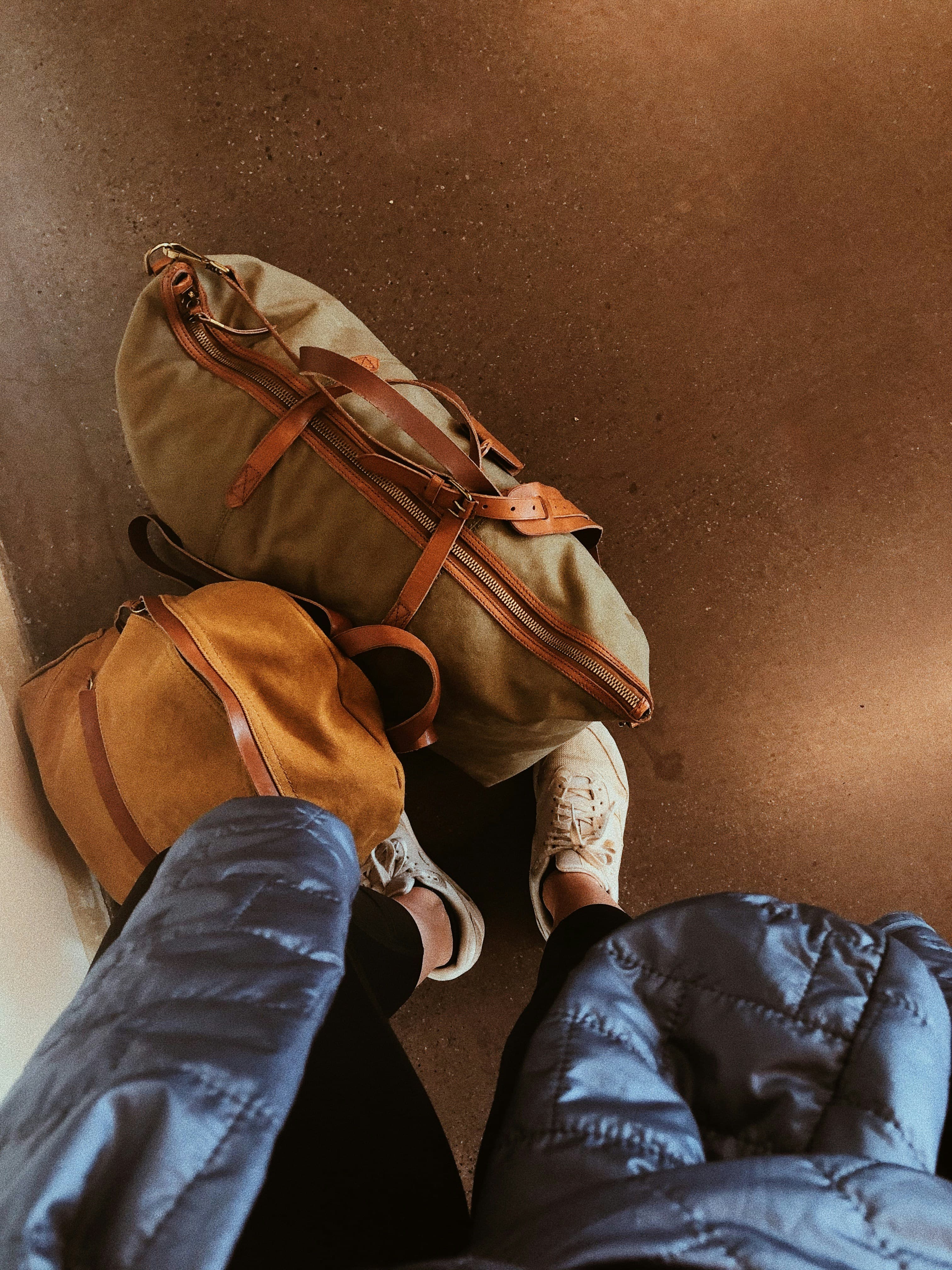 Two backpacks on a warm brown floor, ready for a student trip